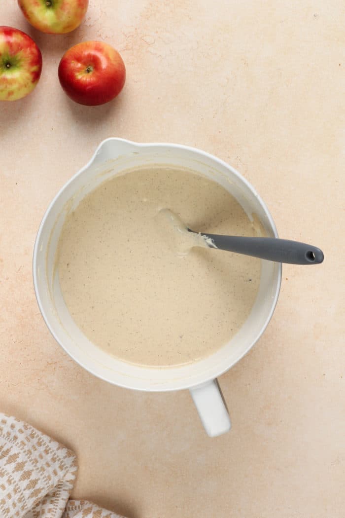 Filling for caramel apple cheesecake in a white mixing bowl.