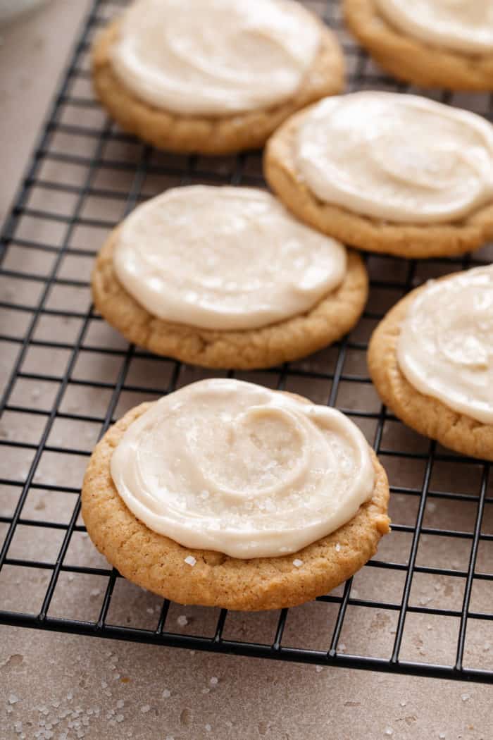 Close up of frosted maple cookies arranged on a wire cooling rack.