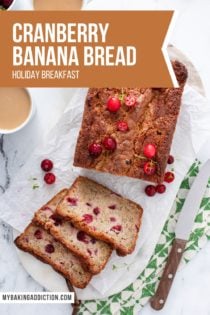 Overhead view of a loaf of sliced cranberry banana bread on a piece of parchment paper. Text overlay includes recipe name.