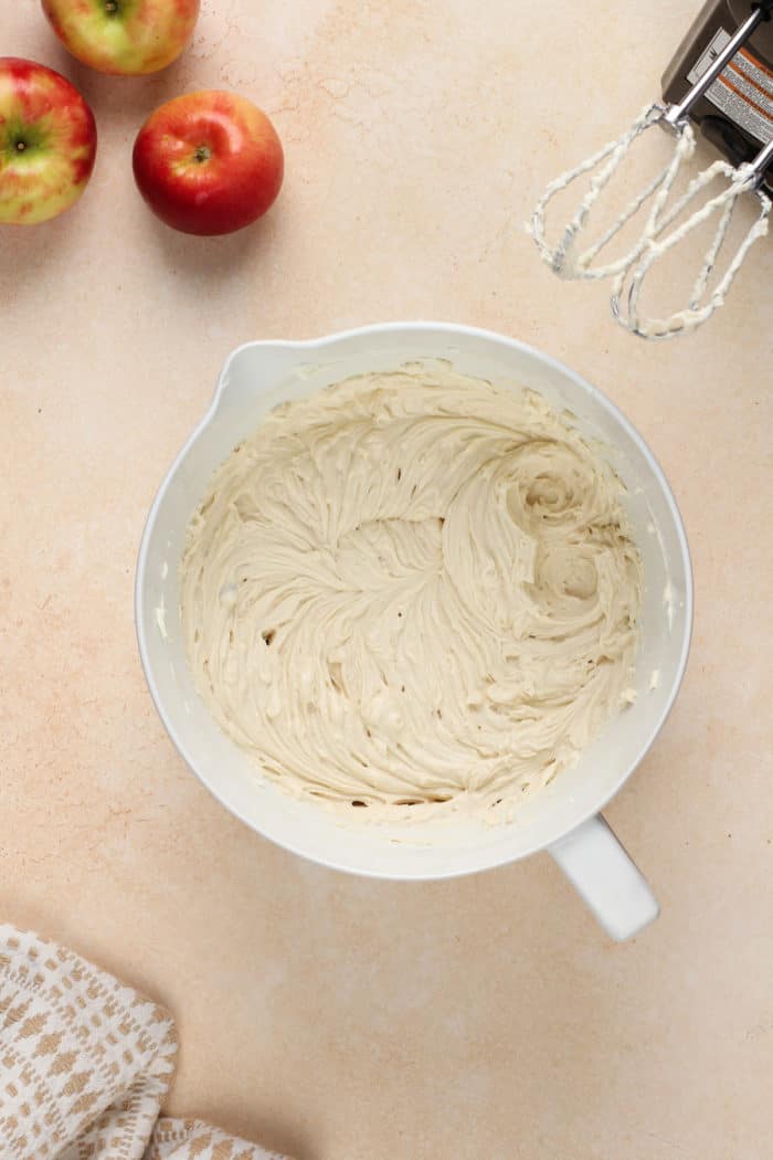 Beaten cream cheese in a white mixing bowl.