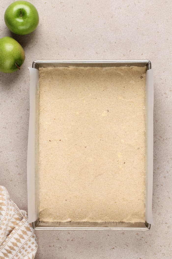 Apple crisp bar shortbread crust in a pan.