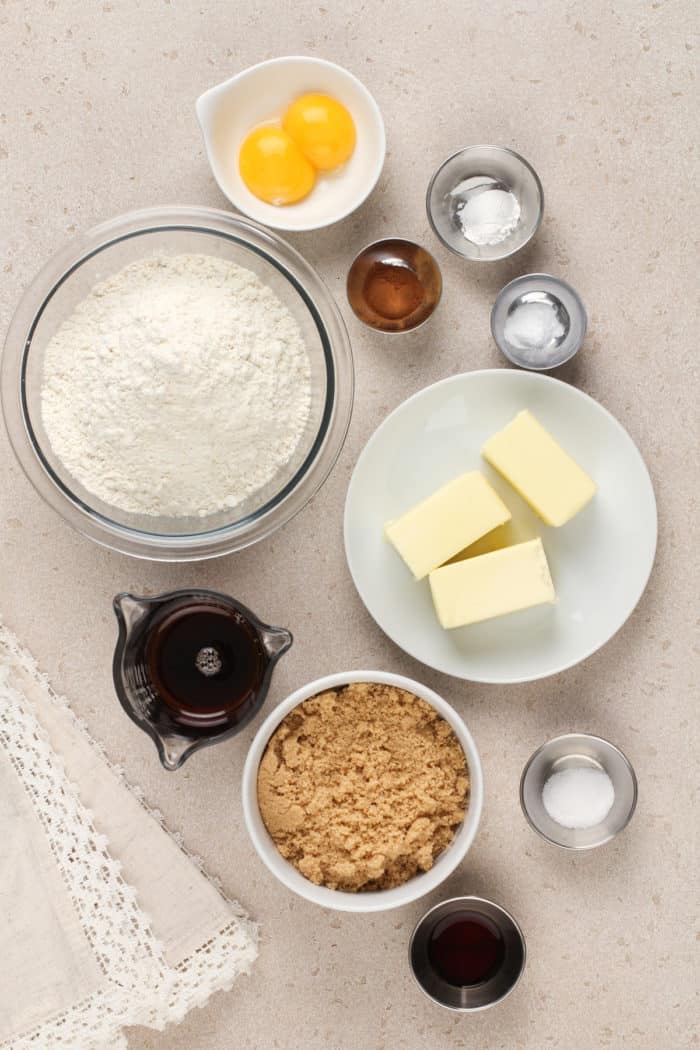 Ingredients for maple cookies arranged on a beige countertop.