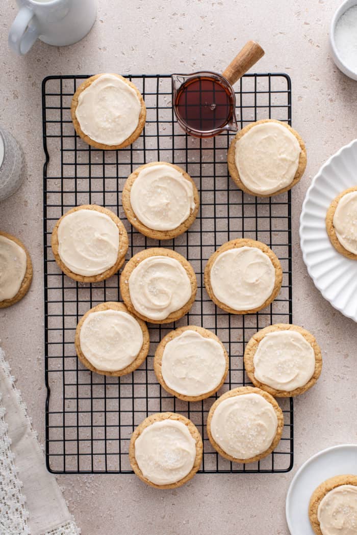 Overhead view of frosted maple cookies arranged on a wire cooling rack.