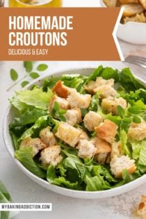 Croutons on top of a green salad in a big, white bowl. Text overlay includes recipe name.