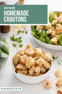 Small white bowl of croutons on a countertop with a bowl of salad in the background. Text overlay includes recipe name.