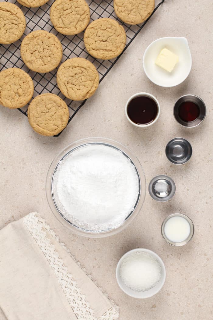 Ingredients for maple frosting next to cooling maple cookies.