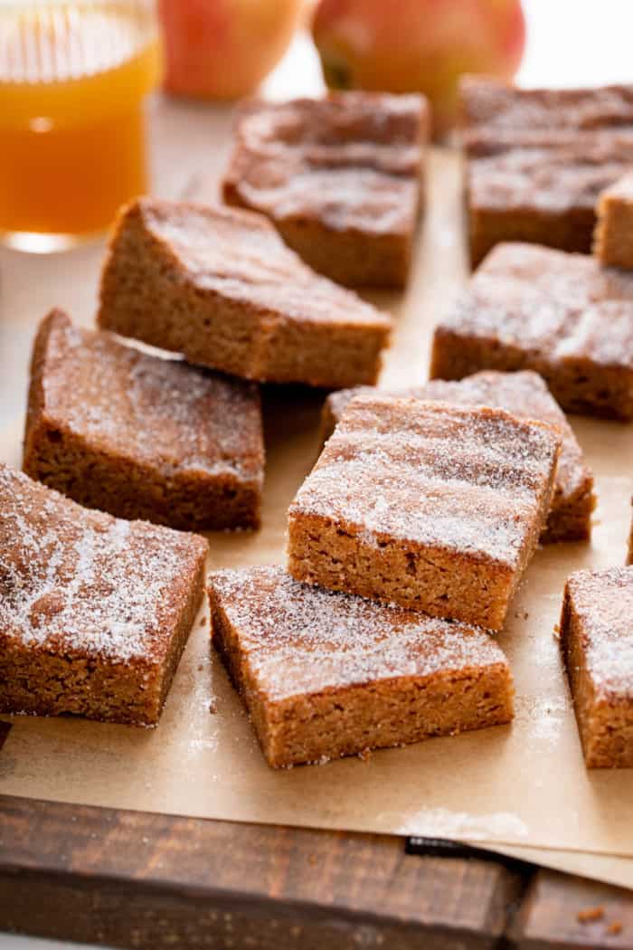 Apple cider blondies scattered on a piece of brown parchment paper.