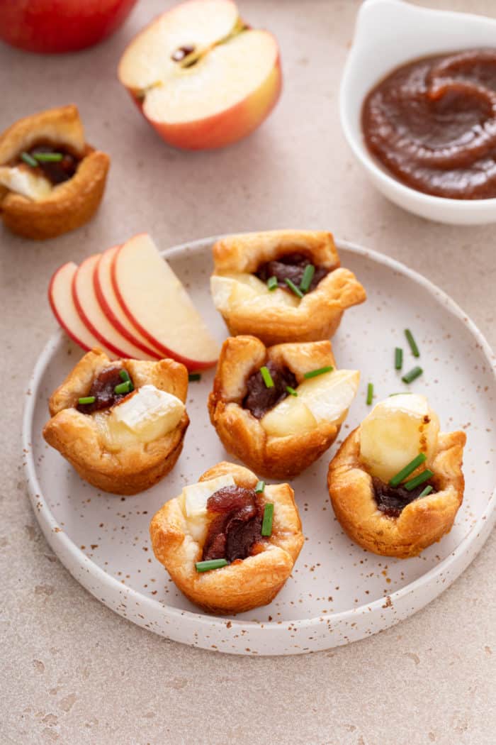 Five apple butter brie bites arranged on a plate.