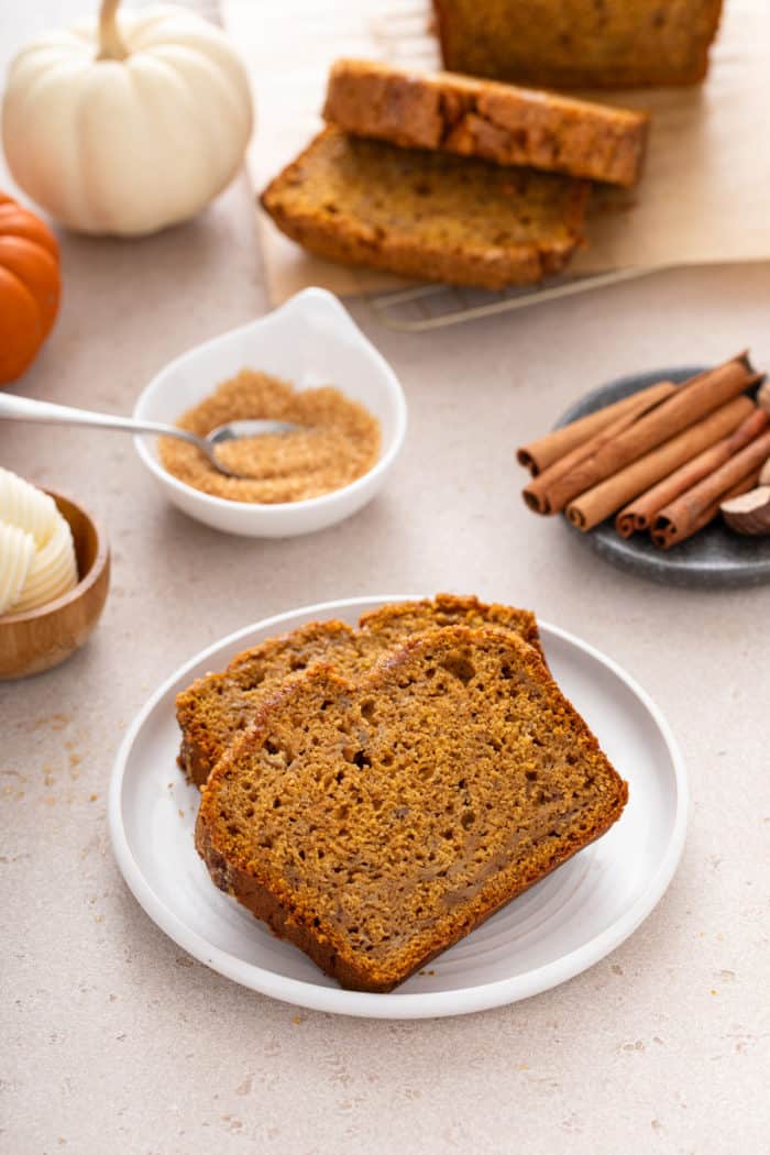 Two slices of pumpkin banana bread on a white plate.