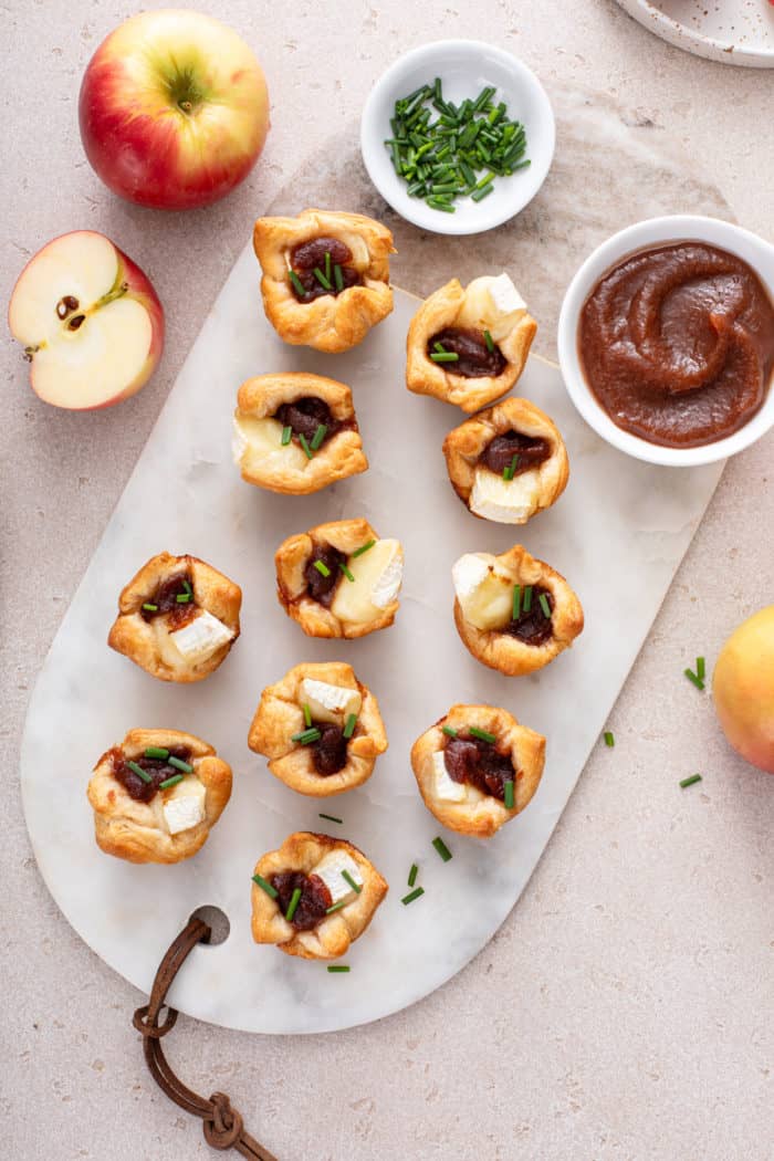 Overhead view of apple butter brie bites on a marble board.