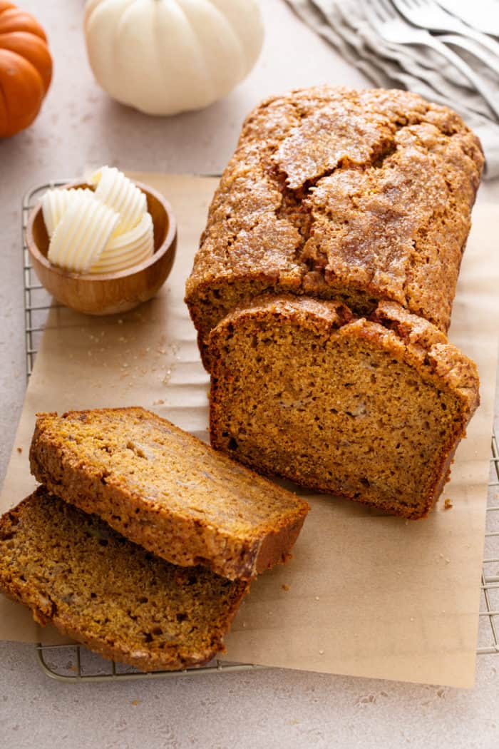 Loaf of pumpkin banana bread with half of the loaf cut into slices.