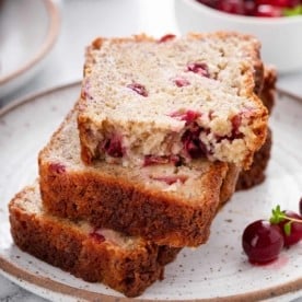 Three slices of stacked cranberry banana bread on a speckled plate.