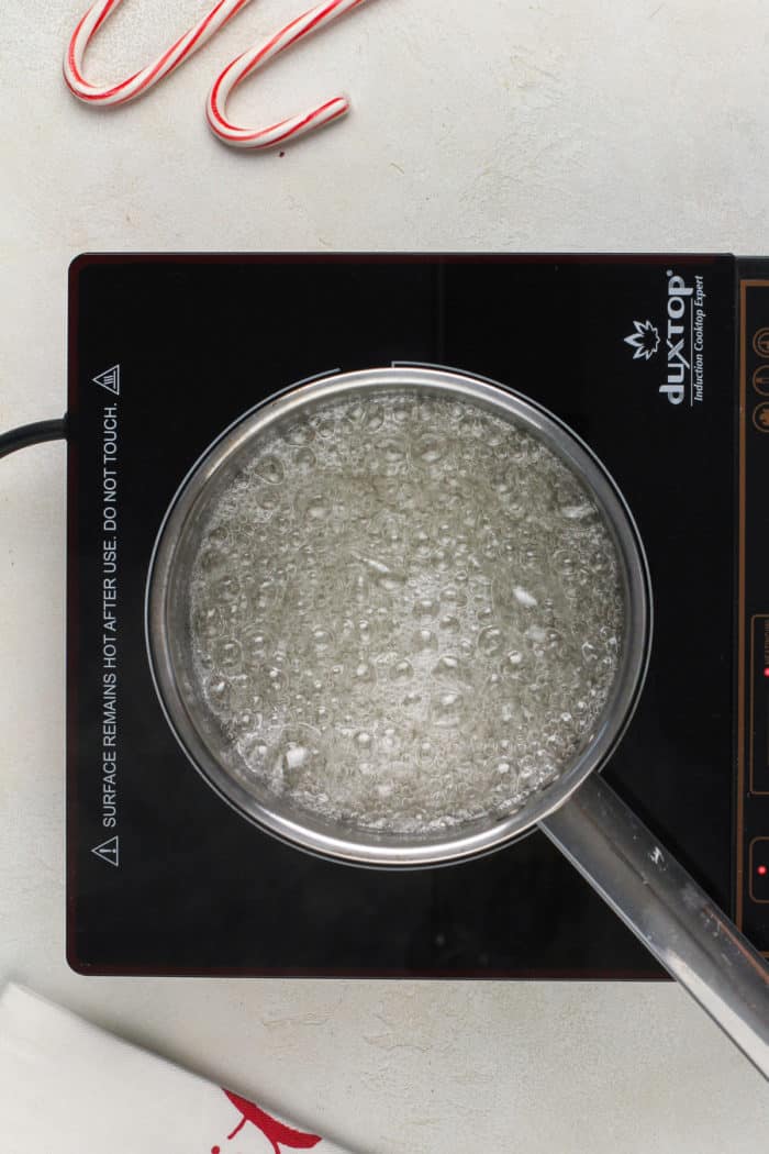 Sugar syrup boiling in a saucepan.