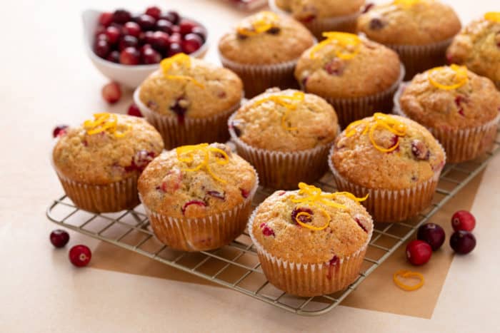 Batch of cranberry orange muffins cooling on a wire rack.