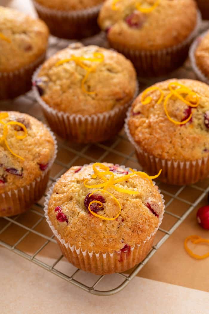 Close up of cranberry orange muffins on a wire cooling rack.