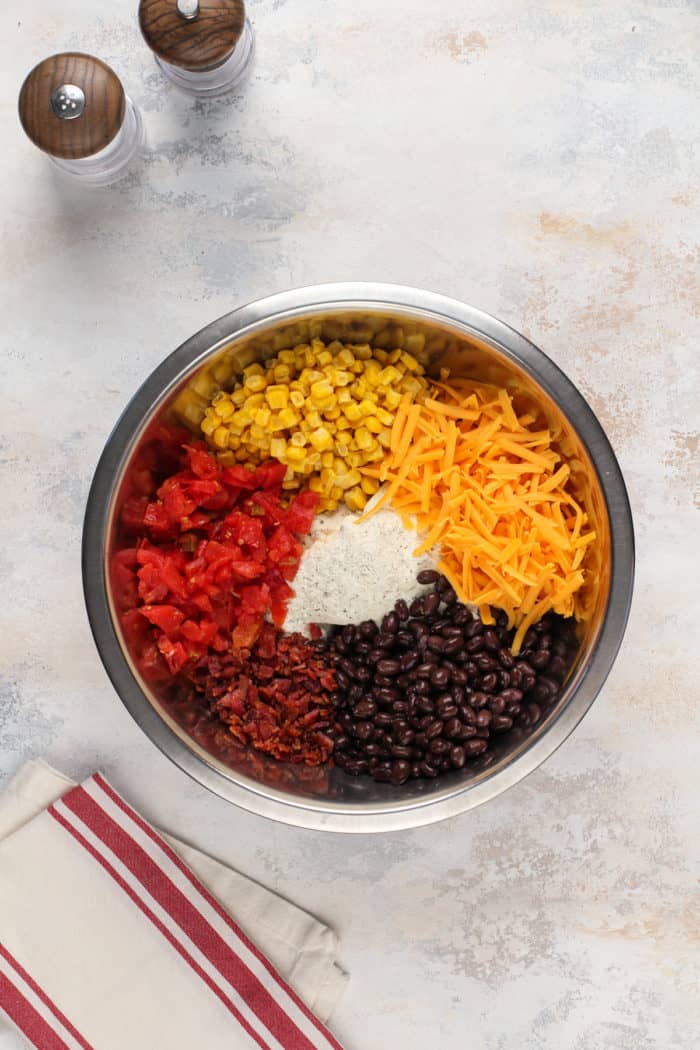 Ingredients for fiesta ranch dip added to a metal mixing bowl.