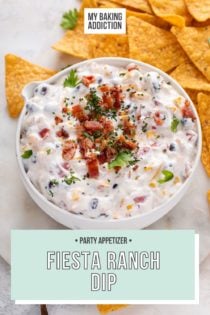 Close up of fiesta ranch dip in a white bowl, garnished with green onions and bacon bits. Text overlay includes recipe name.