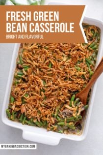 Overhead view of baked fresh green bean casserole with a wooden spoon in the dish. Text overlay includes recipe name.