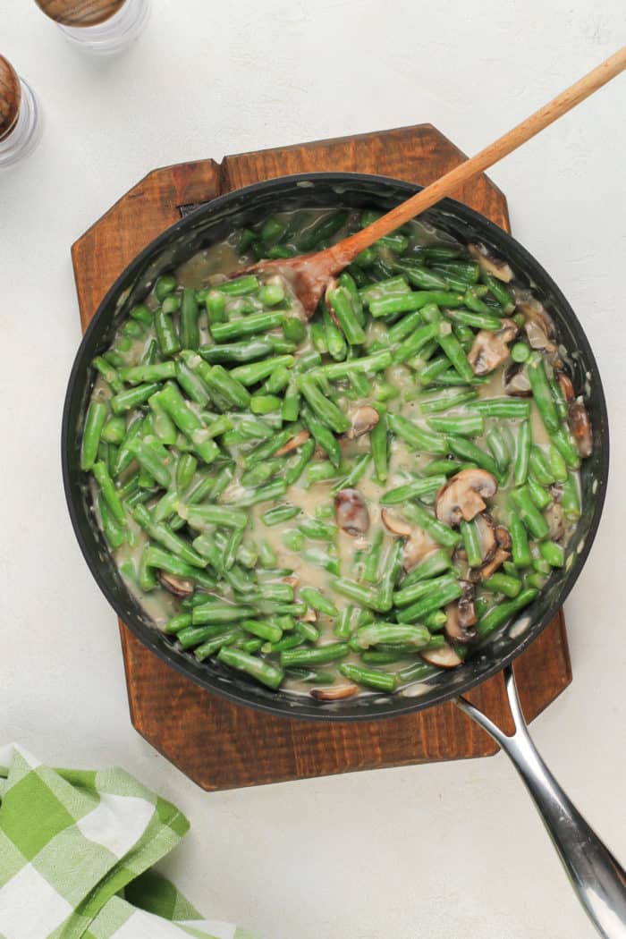 Fresh green bean casserole mixture in a skillet.