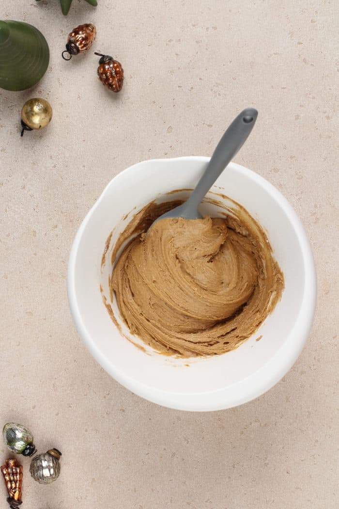 Gingerbread crinkle cookie dough in a white mixing bowl.