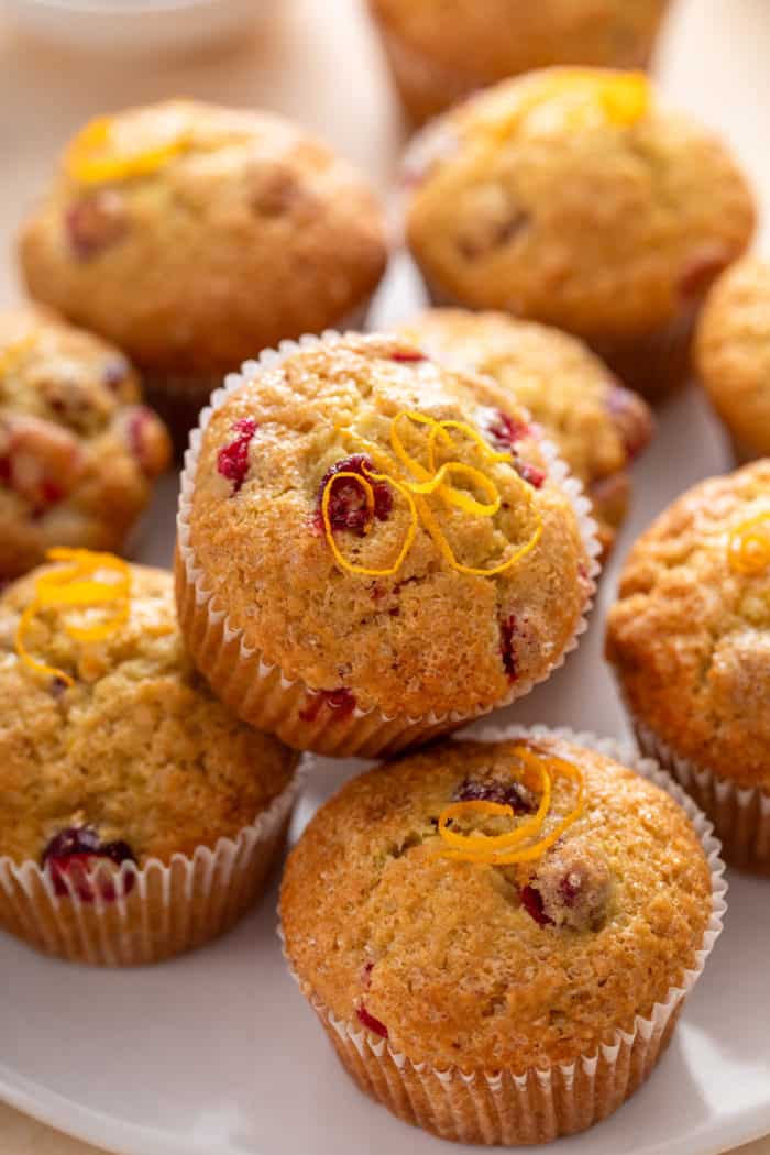 Close up of cranberry orange muffins arranged on a white platter.