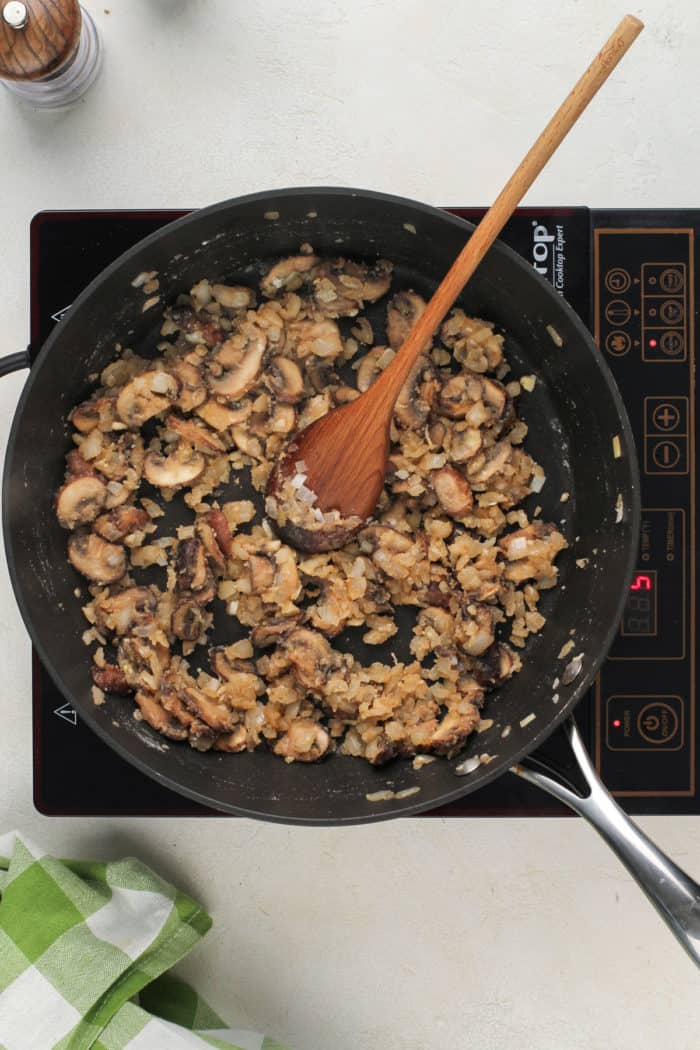 Sauteed mushrooms and onions in a skillet.