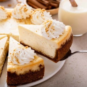 Serving a slice of eggnog cheesecake topped with whipped cream.