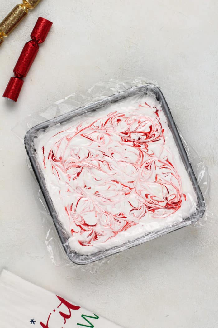 Peppermint marshmallows in a plastic-wrap-lined pan, ready to be cut.