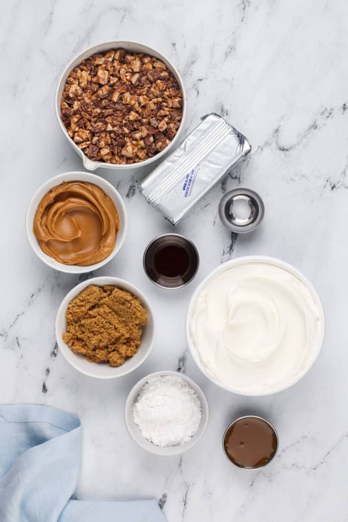 Ingredients for snickers dip arranged on a marble countertop.
