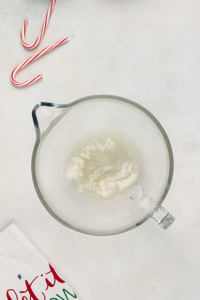 Unflavored gelatin sprinkled over water in a stand mixer bowl.