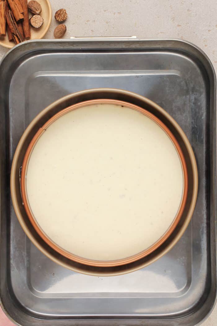 Unbaked eggnog cheesecake in a water bath, ready to go in the oven.