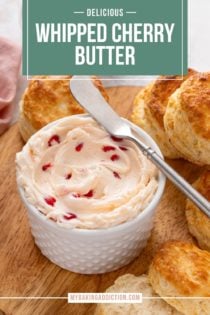 Bowl of whipped cherry butter on a wooden board, surrounded by biscuits. Text overlay includes recipe name.