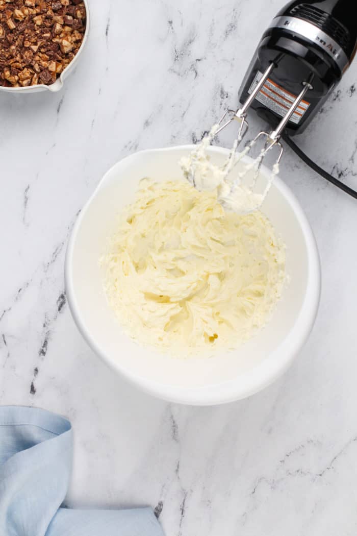 Cream cheese whipped in a white mixing bowl.