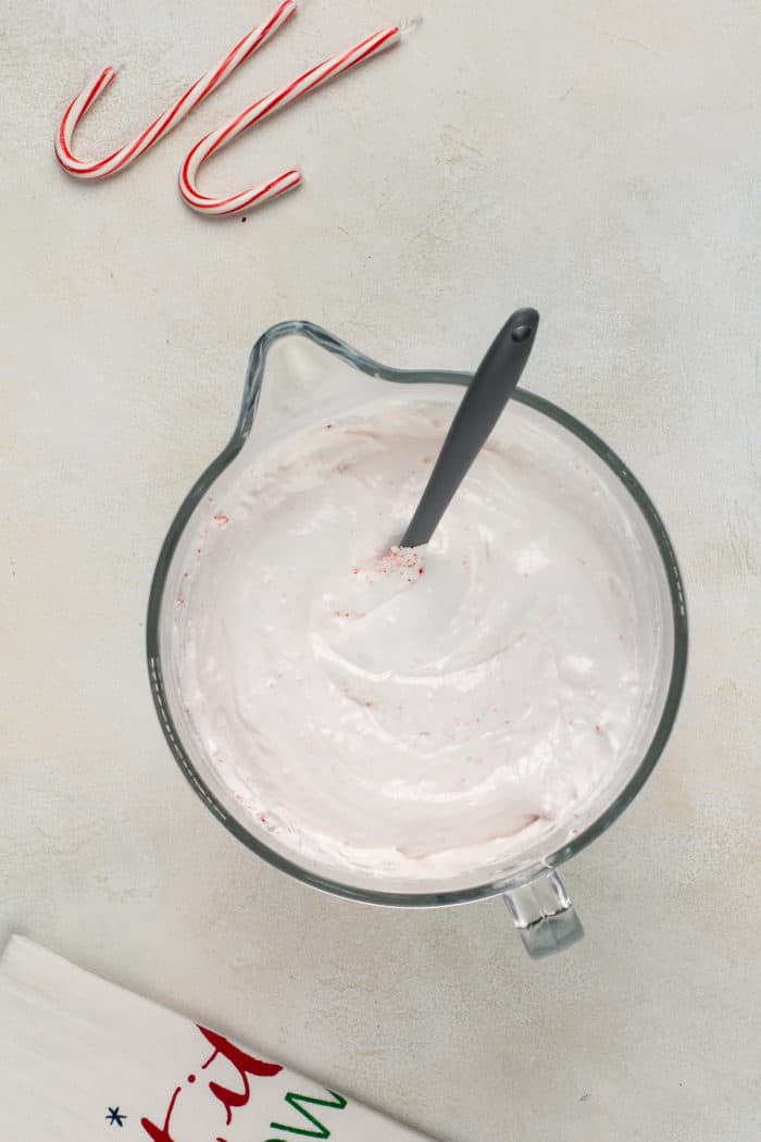 Whipped peppermint marshmallow mixture in a glass mixing bowl.