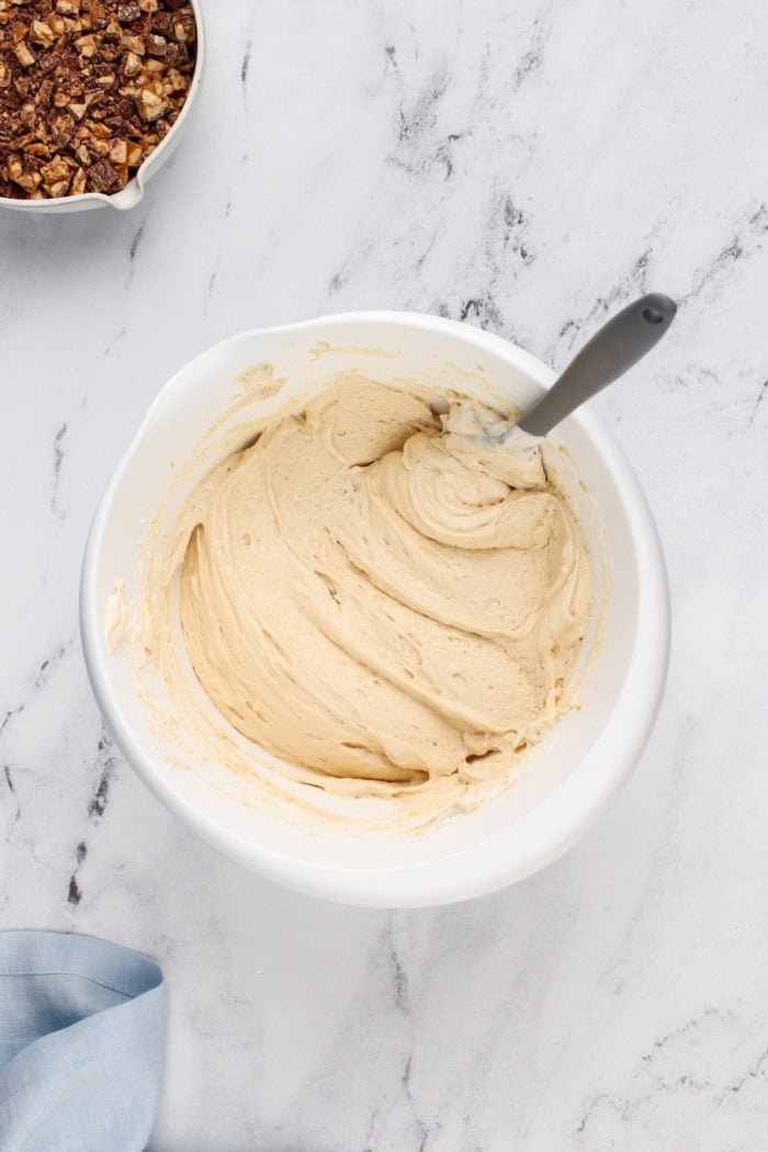 Snickers dip base in a white bowl, waiting for chopped snickers bars to be added.