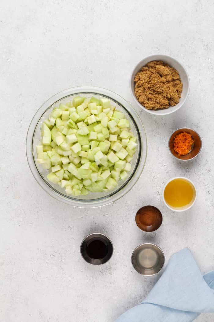 Ingredients for apple compote arranged on a light-colored countertop.