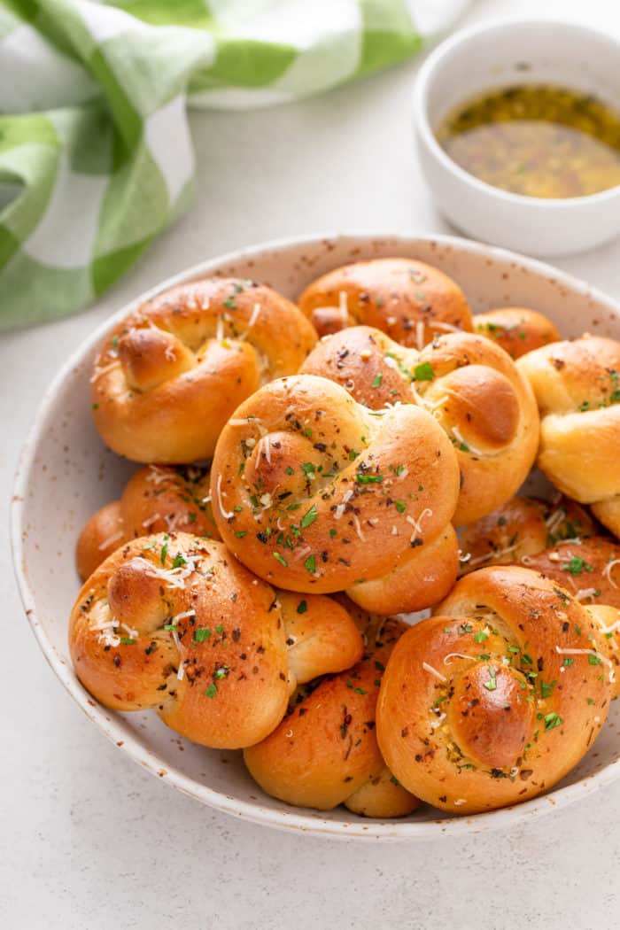 Garlic knots piled in a white bowl.