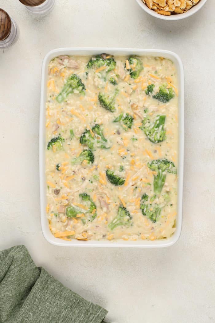 Mixture for chicken broccoli rice casserole spread in a white casserole dish.