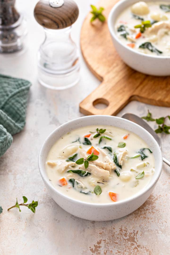 Served chicken gnocchi soup with a side of salad and bread