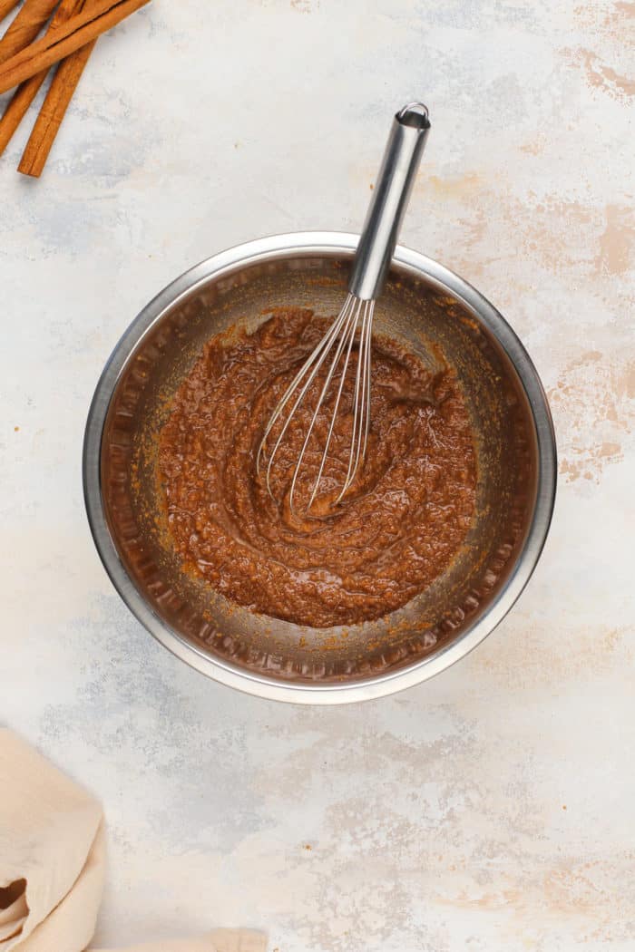 Cinnamon sugar swirl mixture for cinnamon roll cake in a metal mixing bowl.