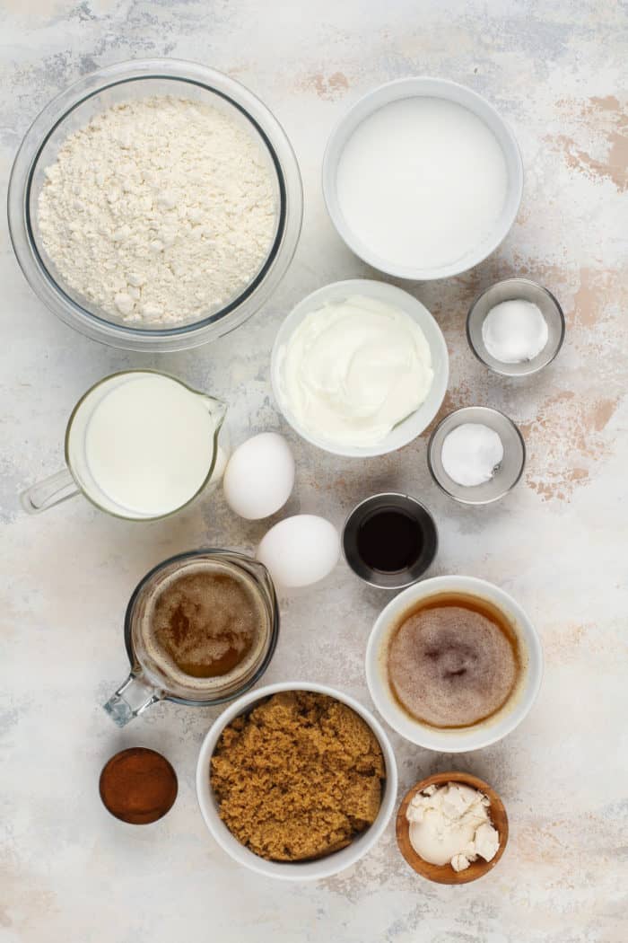 Ingredients for cinnamon roll cake arranged on a beige countertop.