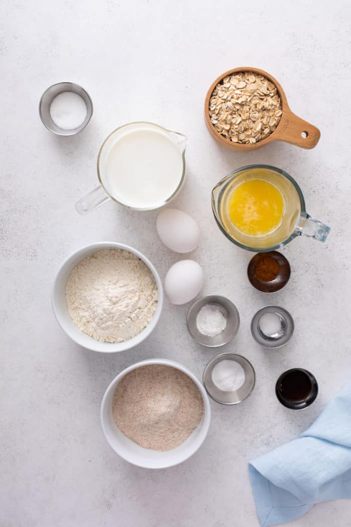 Ingredients for oatmeal pancakes arranged on a light-colored countertop.
