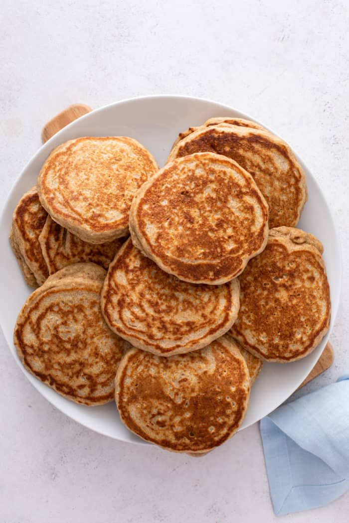 White plate filled with cooked oatmeal pancakes.