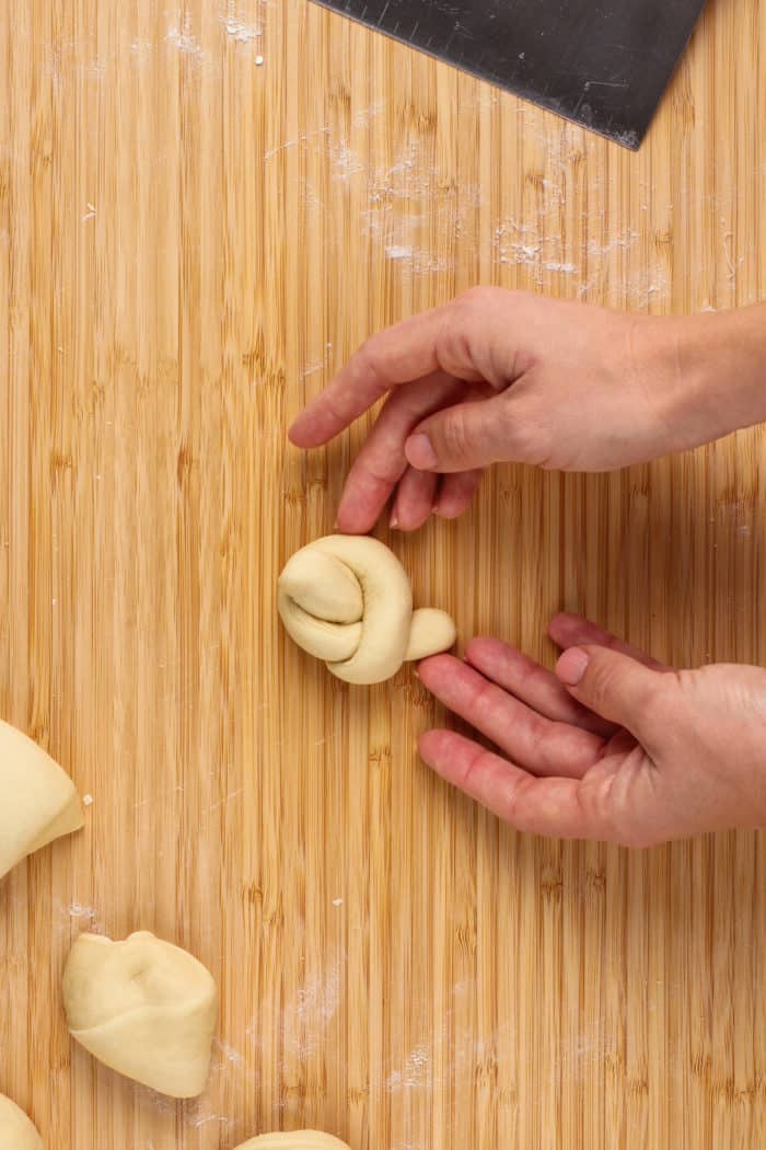 Shaped garlic knot on a wooden board.