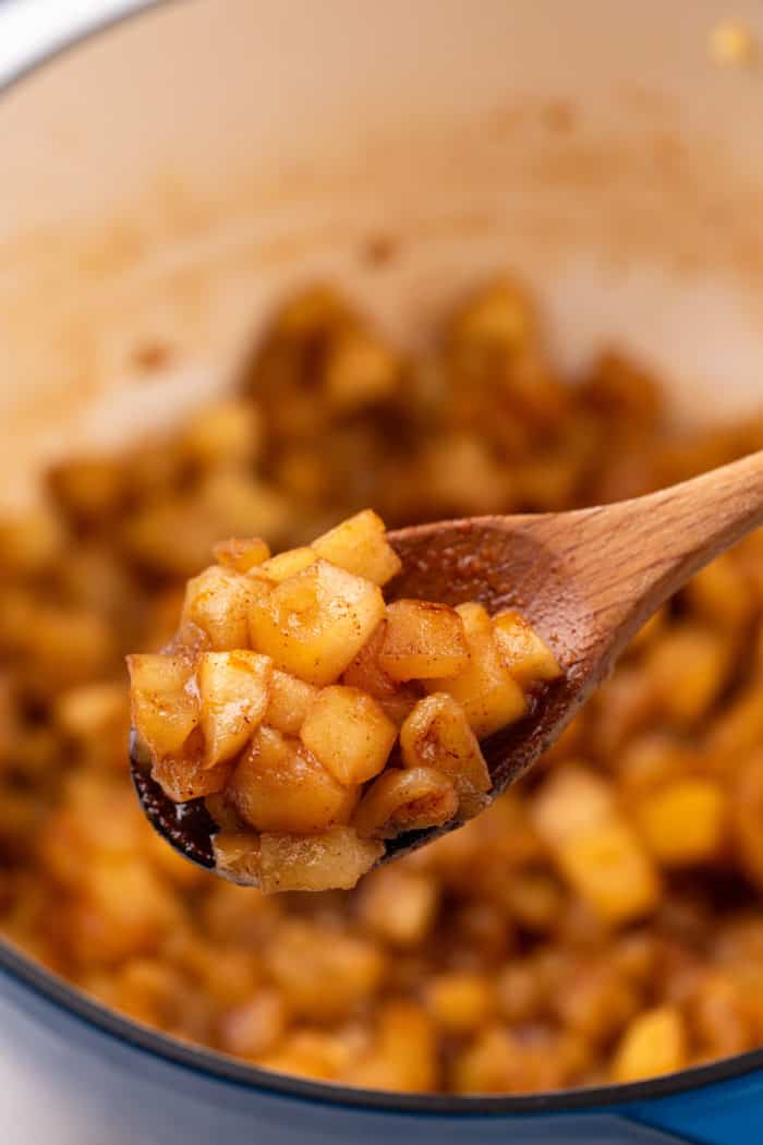 Wooden spoon holding up apple compote.