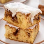 Two slices of cinnamon roll cake stacked on a plate.