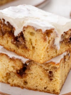 Two slices of cinnamon roll cake stacked on a plate.