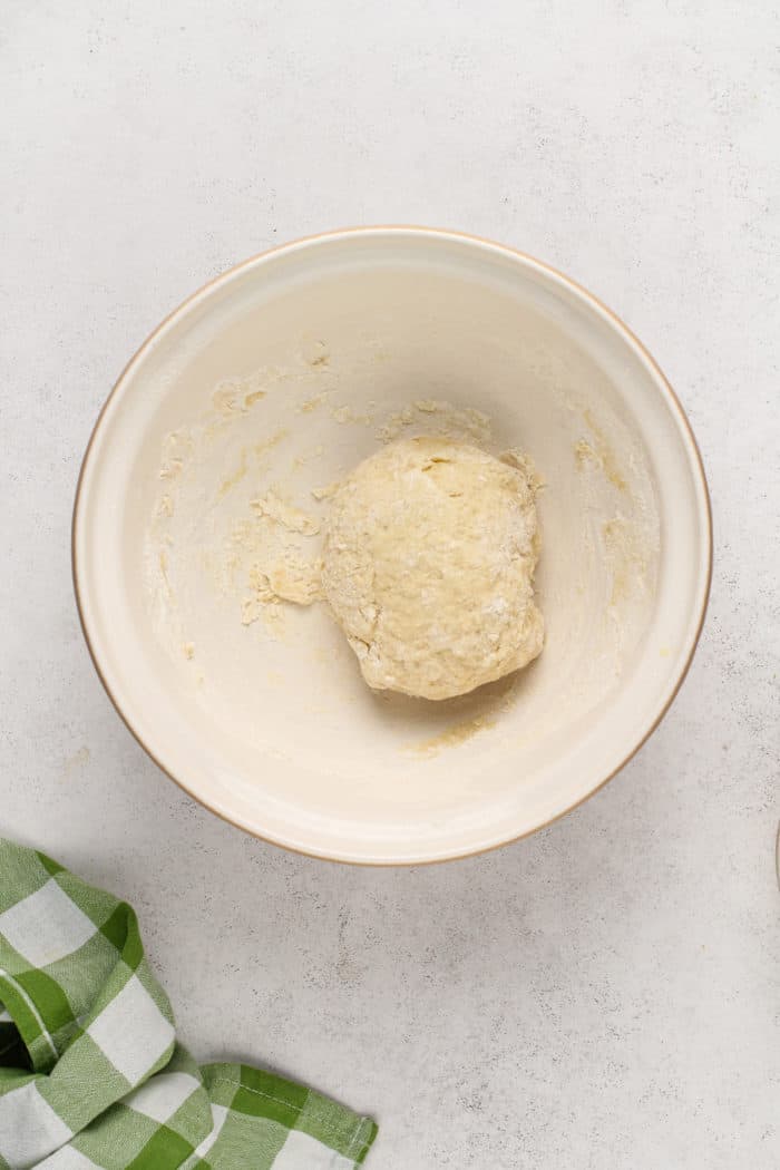 Unkneaded dough for garlic knots in a ceramic bowl.