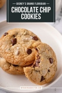 Three grand floridian chocolate chip cookies on a white plate. Two are stacked and the third has a bite taken from it and is leaning against the other two. Text overlay includes recipe name.