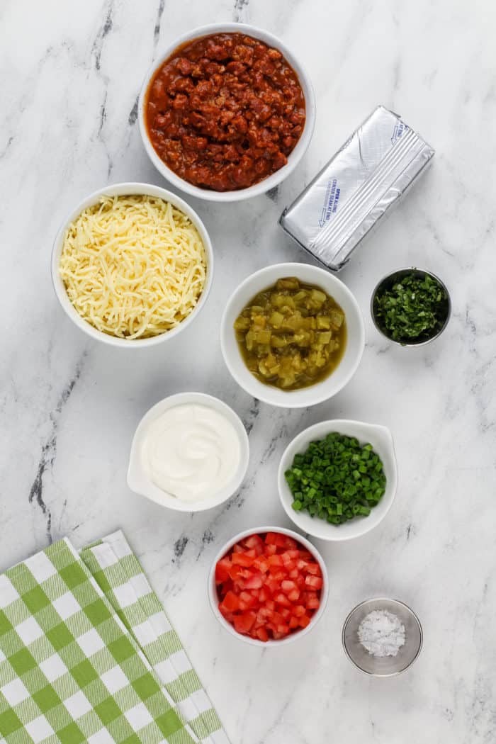 Ingredients for easy chili cheese dip arranged on a marble countertop.